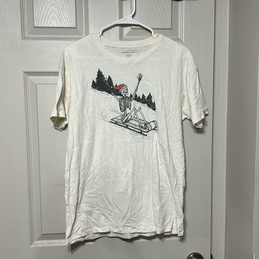 White T-shirt with skeleton in Santa hat, riding sleigh. Size XS/S